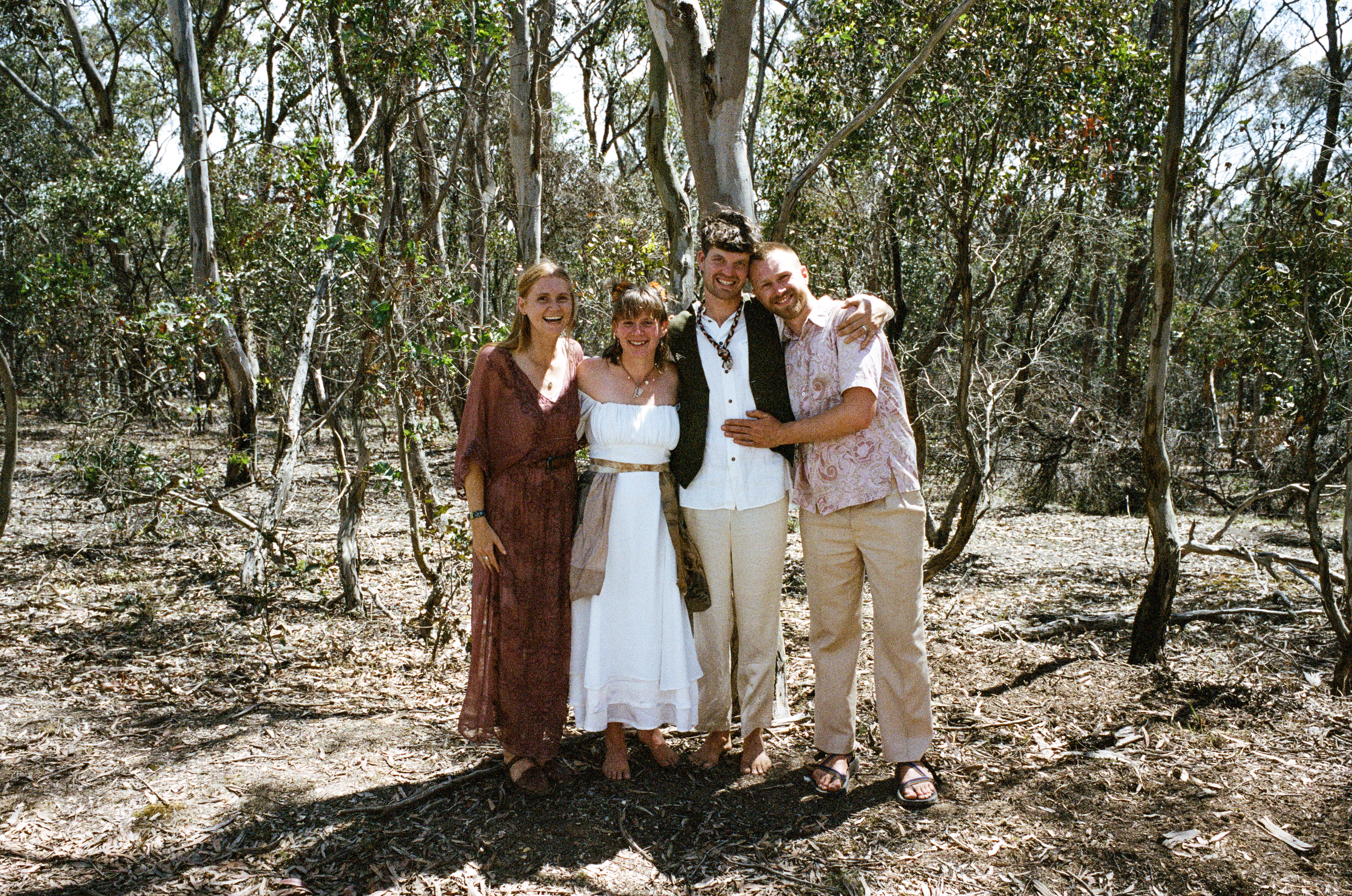 Tom Allen and a couple celebrating after an intimate outdoor bush ceremony among Australian gum trees